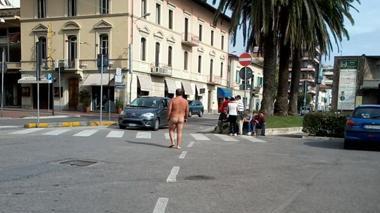 Tutto nudo si mette a cantare tra le auto