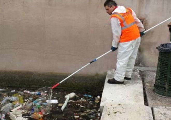 Lattine e bottiglie “pescate” nel fosso di viale Caprera