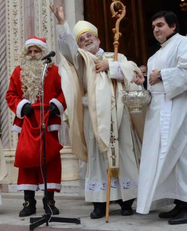 Vescovo e Babbo Natale lanciano le caramelle ai bambini 