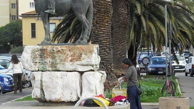 Fa il bucato sotto al monumento alla stazione