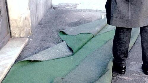 Panno in strada arrotolato un uomo inciampa e si fa male
