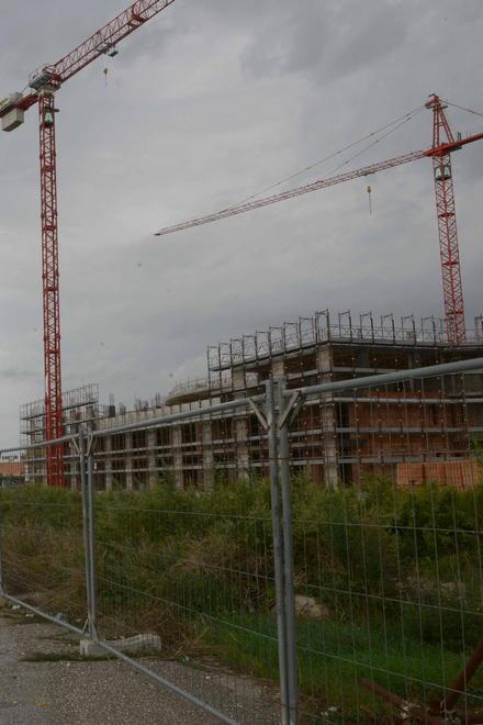 Due passi tra erba alta, reti arrugginite e cartelli sbiaditi