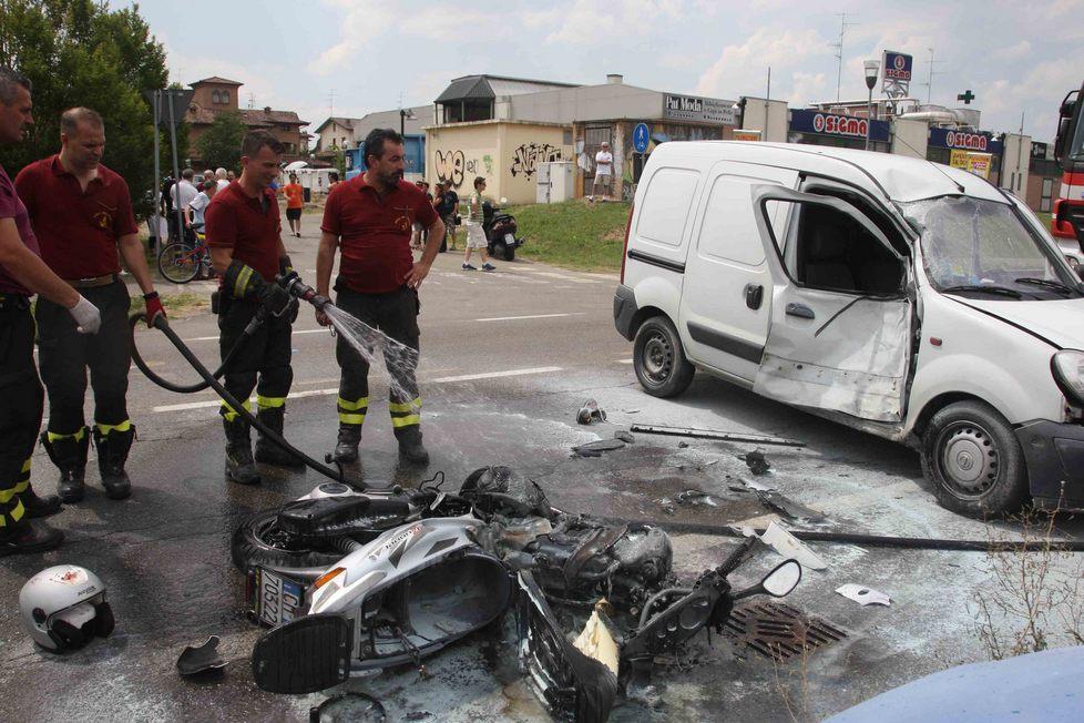 Scooter si scontra con un'auto e prende fuoco 