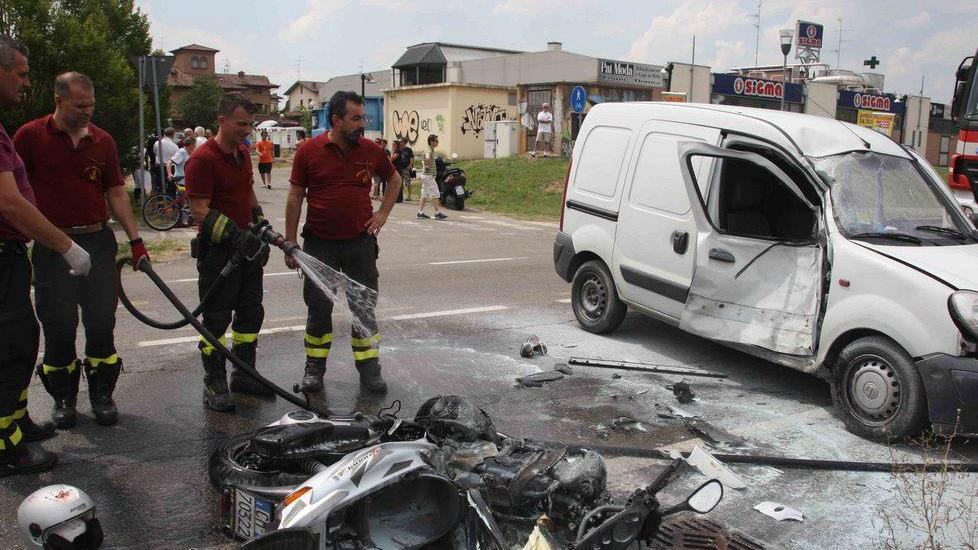 Scooter si scontra con un'auto e prende fuoco