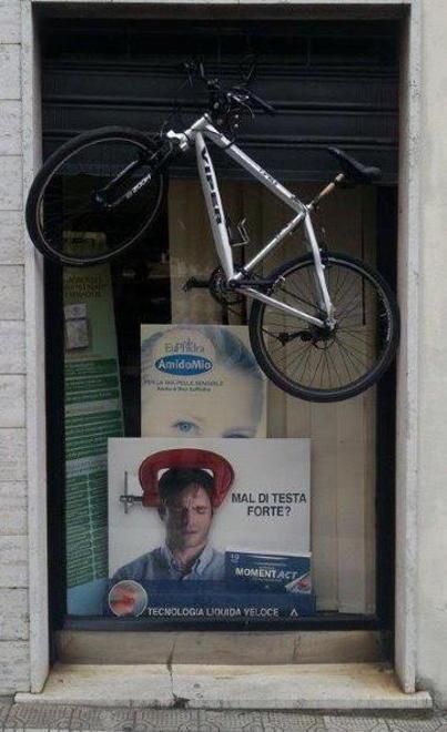 Bicicletta appesa alla farmacia 