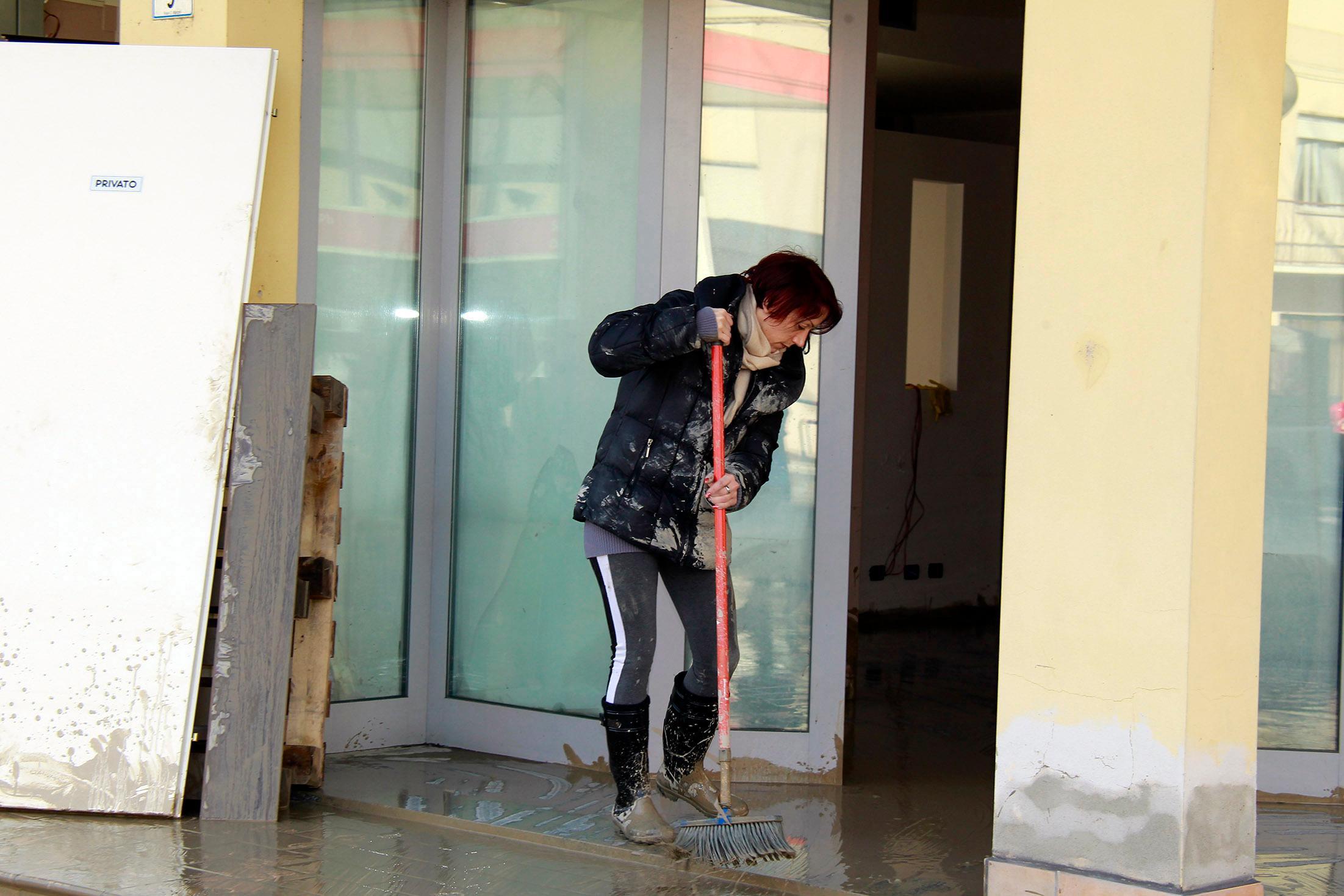L'intervento di una residente costretta a ripulire dal fango 