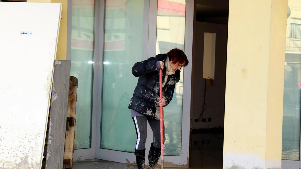 L'intervento di una residente costretta a ripulire dal fango