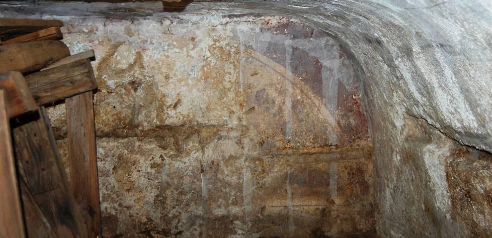 Una tomba affrescata coperta da erbacce e rifiuti