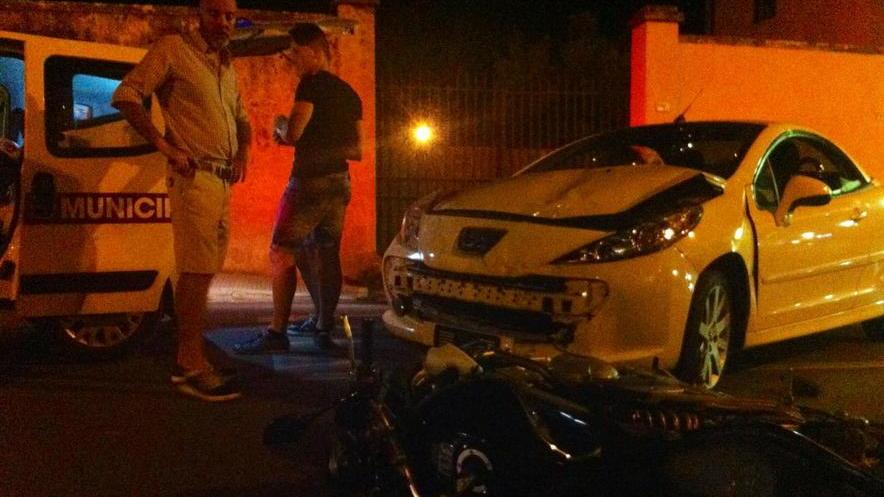 Finisce con la moto sotto un’auto