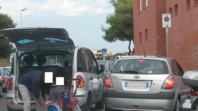 Il posto riservato è occupato così al disabile tocca la strada